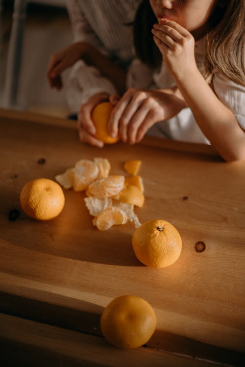 女孩吃橙色水果 · 免费素材图片