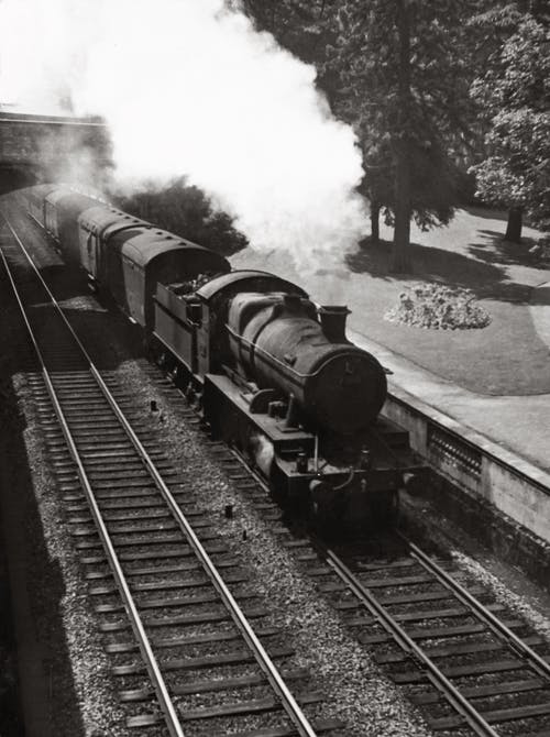 火车在铁路上的灰度摄影 · 免费素材图片