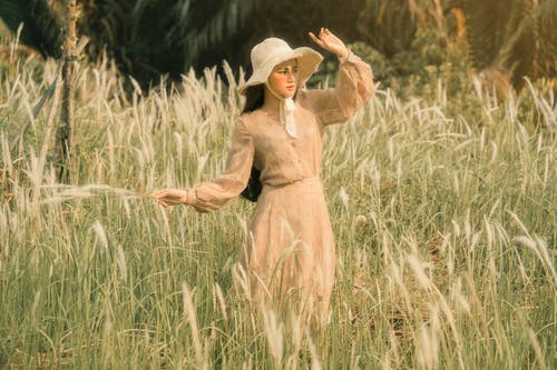 帽子的妇女在领域的草中 · 免费素材图片