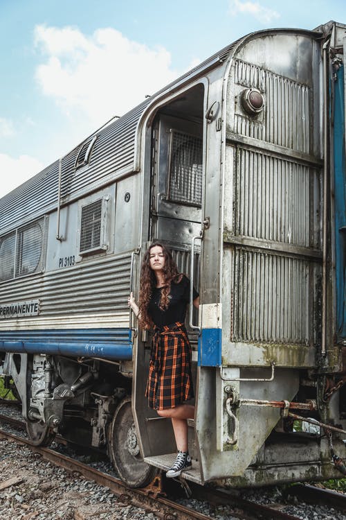 女人站在灰色的火车上 · 免费素材图片