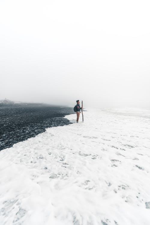 站在雪地上的蓝色外套和蓝色牛仔牛仔裤的男人 · 免费素材图片