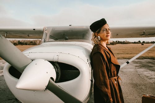 女人靠在一架飞机 · 免费素材图片