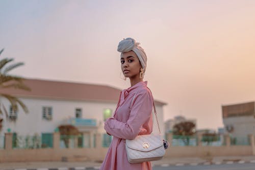 皮包粉色连衣裙的女人的选择性聚焦照片 · 免费素材图片