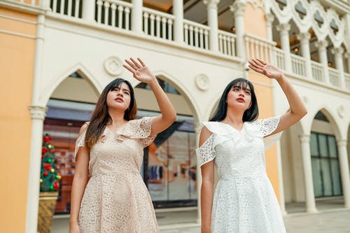 两个女人站在白色的大楼附近 · 免费素材图片