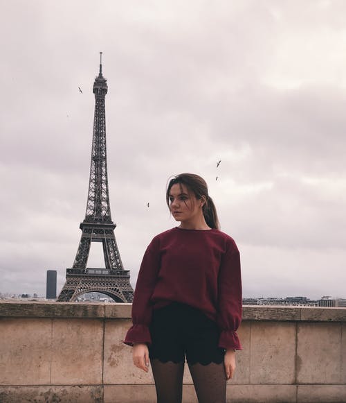 红色的长袖衬衫，站在埃菲尔铁塔附近的女人 · 免费素材图片