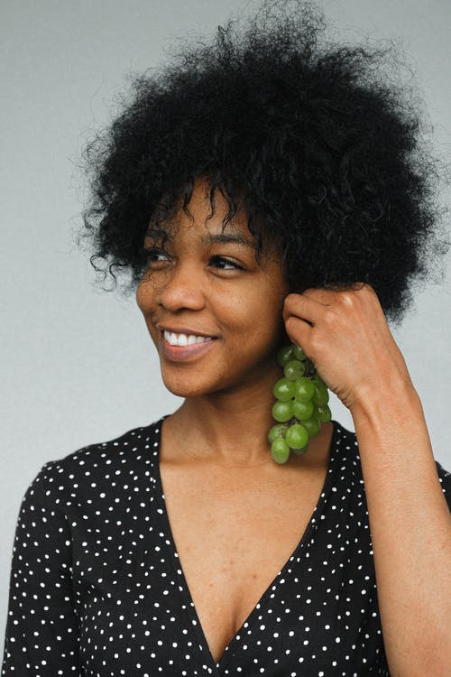 微笑的女士用天然葡萄作为耳环 · 免费素材图片