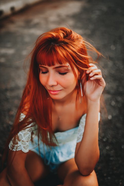 化妆和蹲在人行道上的红头发的时髦女人 · 免费素材图片