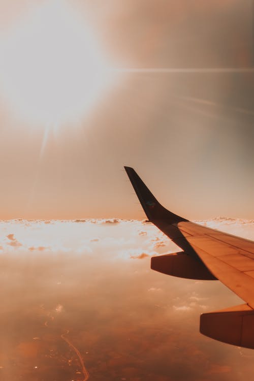 飞机机翼上方云层对明亮的阳光 · 免费素材图片