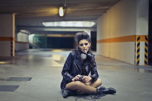 在地下停车场吸烟的女性摇滚歌手 · 免费素材图片