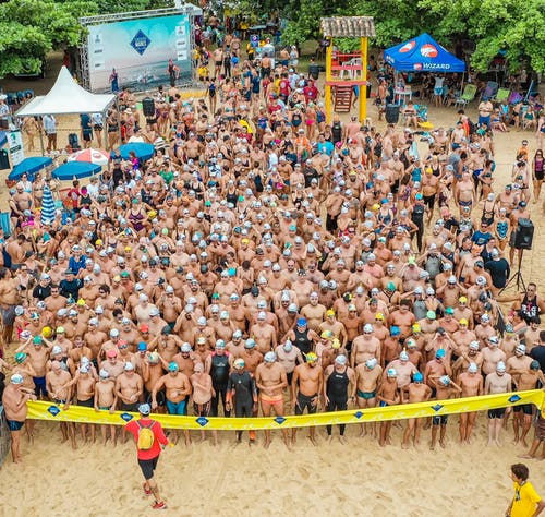 拥挤的海滩，游泳者参加比赛 · 免费素材图片