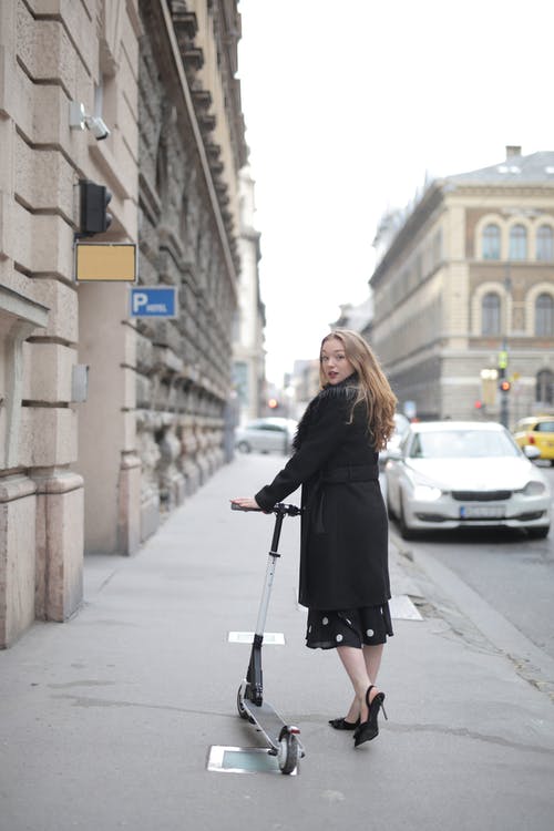 黑色的长袖外套，站在人行道上的女人 · 免费素材图片