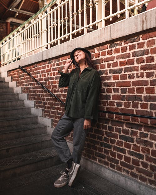 绿色的长袖，倚在混凝土楼梯旁边的砖墙上的女人 · 免费素材图片