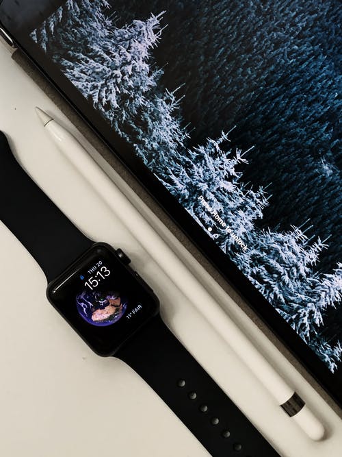 黑苹果手表在手写笔旁边的平躺照片 · 免费素材图片