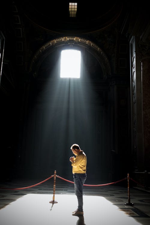 认不出来的人在教堂里在阳光下祈祷 · 免费素材图片