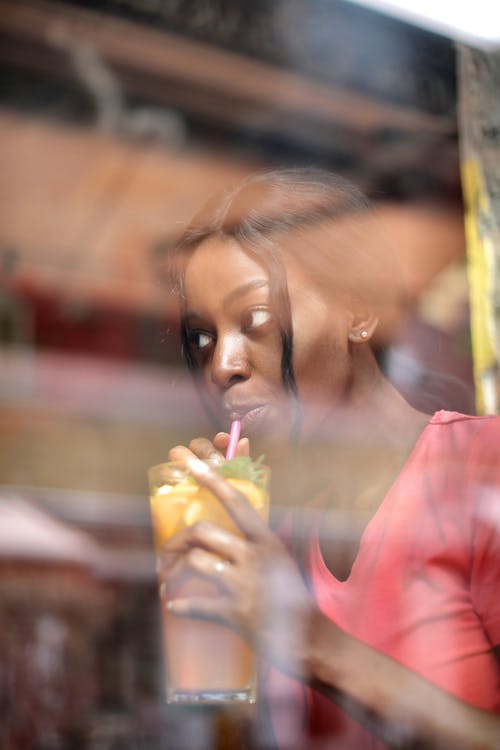年轻女性喝鸡尾酒用稻草 · 免费素材图片