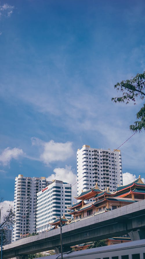 东方神庙和现代建筑在市区在阳光灿烂的日子 · 免费素材图片