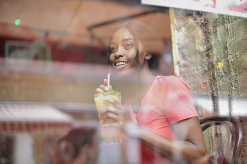 杯果汁在咖啡馆里的年轻女子 · 免费素材图片
