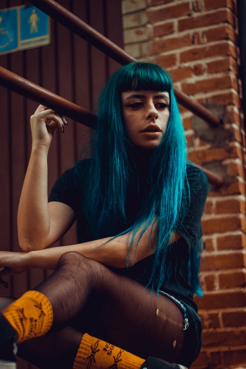 在楼梯上休息的蓝头发的女人 · 免费素材图片