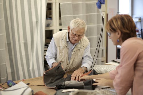 高级男工匠与女助手一起创建袋 · 免费素材图片