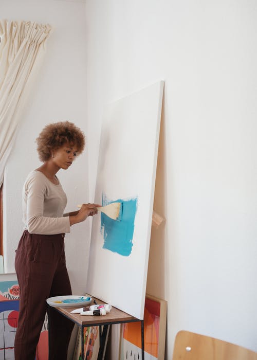 女人用蓝色油漆绘画的照片 · 免费素材图片