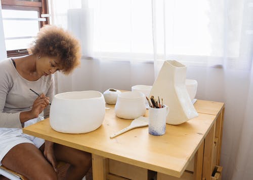 聚焦年轻画家画陶瓷碗 · 免费素材图片