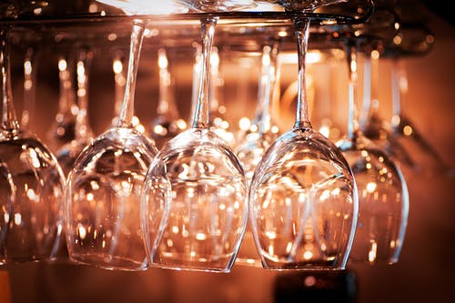 晚上挂在餐厅的干燥架上的发光玻璃器皿 · 免费素材图片