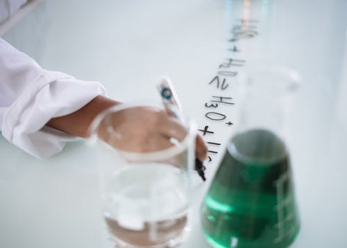 作物化学家在液体实验期间在白板上记科学笔记 · 免费素材图片