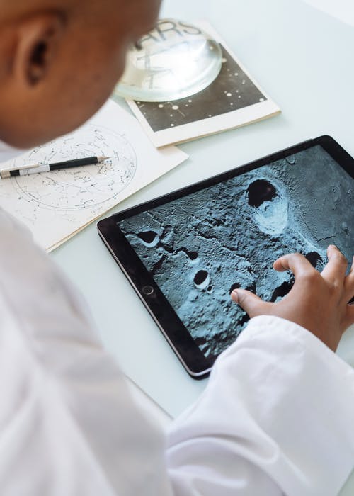 作物天体物理学家在大学中使用平板电脑时探索月球表面 · 免费素材图片