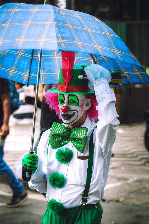 滑稽的小丑化妆和服装在街与伞 · 免费素材图片