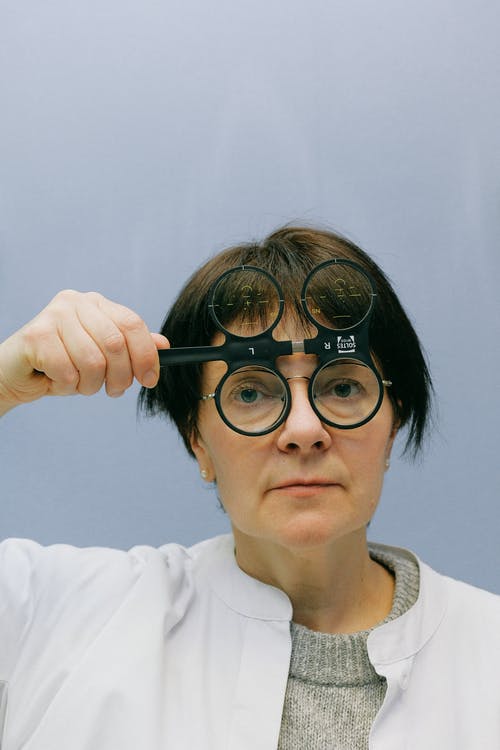 女医生使用带有四个镜头的眼科放大镜 · 免费素材图片