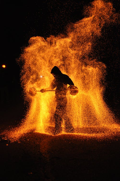 人站在火上的岩石的轮廓 · 免费素材图片