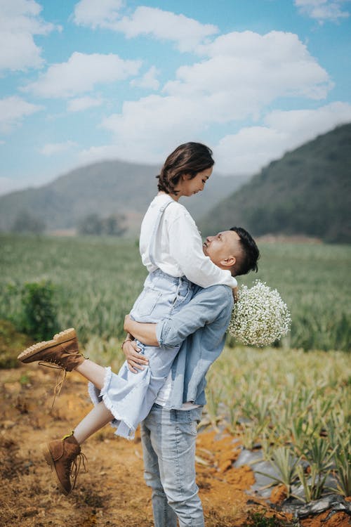 拿着花束的人运载的妇女 · 免费素材图片