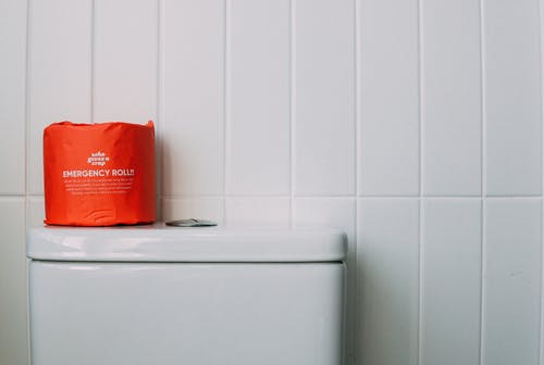 白色陶瓷马桶上的红色厕纸 · 免费素材图片