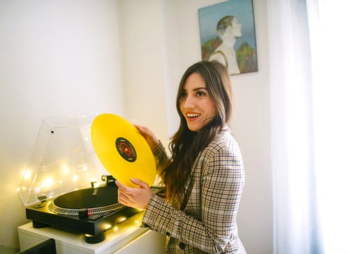 女人抱着黄色黑胶唱片 · 免费素材图片