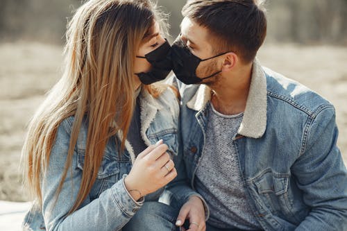 恩爱的小夫妻，戴着黑色医疗口罩接吻 · 免费素材图片