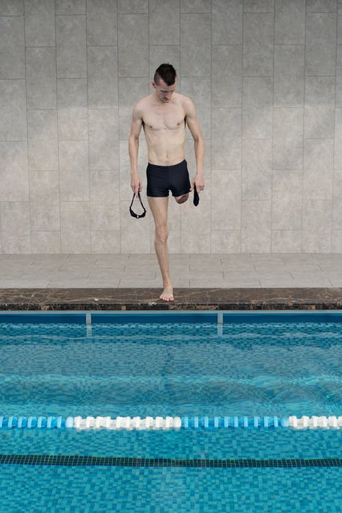 黑色短裤站在游泳池旁的男人 · 免费素材图片