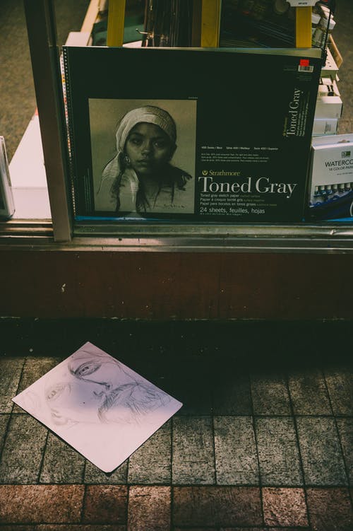 在艺术商店橱窗附近的人行道上的铅笔素描 · 免费素材图片