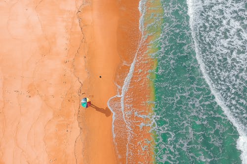 遥远的不可识别的人，在波浪的海洋沙质海岸 · 免费素材图片