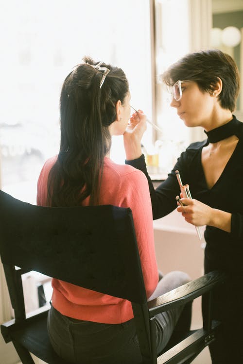 女visagiste在模型上化妆 · 免费素材图片