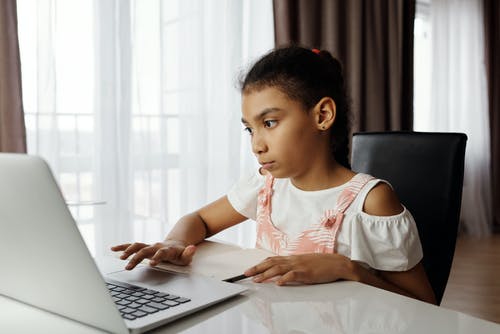 使用一台笔记本电脑的年轻女孩 · 免费素材图片