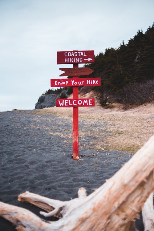与远足方向在海滩上的红色标志 · 免费素材图片