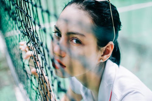 网背后的运动服的年轻女子 · 免费素材图片