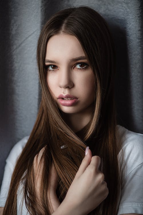诱人的年轻女模特动人的头发，灰色的墙上 · 免费素材图片