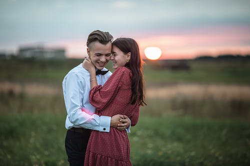 拥抱在浪漫约会期间的愉快的年轻夫妇本质上在日落 · 免费素材图片