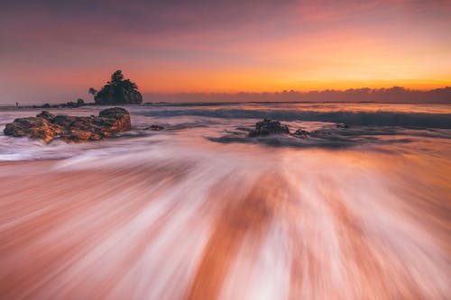 波涛汹涌的海面，日落时海滩上快速的水流 · 免费素材图片