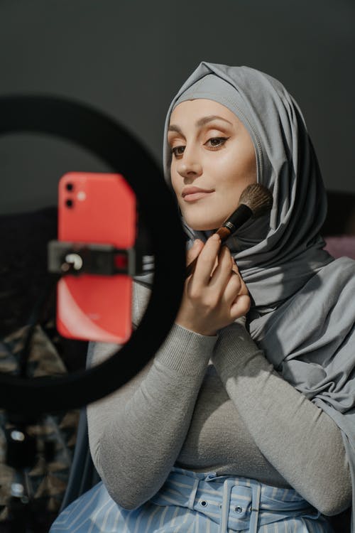 拿着红色智能手机的灰色头巾的女人 · 免费素材图片