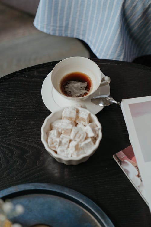 带白色陶瓷杯和不锈钢勺的白色陶瓷板 · 免费素材图片