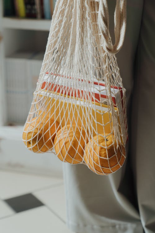 白色塑料袋上的橙色和黄色网 · 免费素材图片