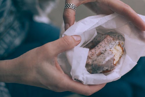 裁剪纸袋美味甜甜圈的人 · 免费素材图片