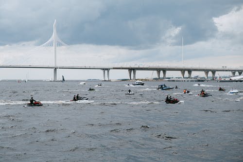 人们骑着小船在海上白云下 · 免费素材图片